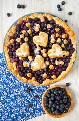 homemade blueberry pie on white wooden surface