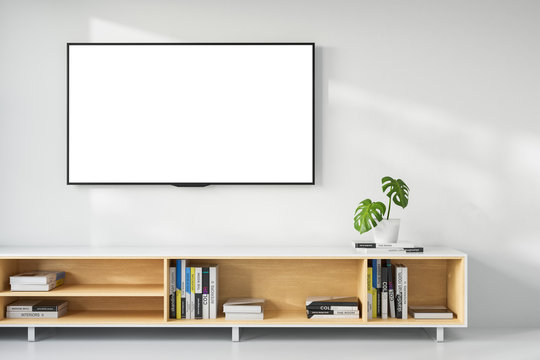 Wooden shelf with books on a background of a white wall in a bright room, a TV hanging on the wall. Mock Up. 3d rendering