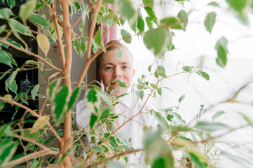 Portrait of fiance holding a pot with plant in his hands.