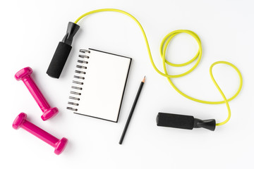 Fitness accessories with empty notebook on white background. Gym concept. Top view