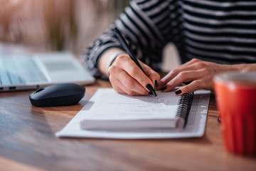 Woman writing notes in notebook