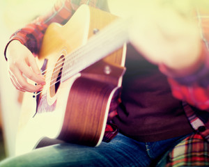 Close-up girl is playing acoustic guitar.
