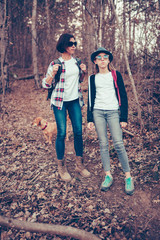 Mother and daughter standing in forest with the dog