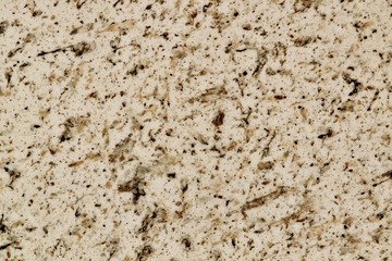 Brown fleck patterns captured in a full frame background on a smooth white marble surface.