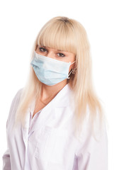 Close up of a young female nurse in mask looking at the camera.