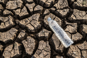 Water bottles on dry soil with dry and cracked soil,global warming