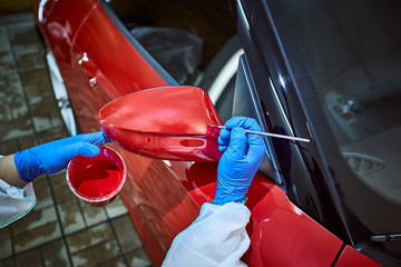 Tinting defects of a red car paint on the service