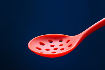 silicone kitchen skimmer on dark blue background