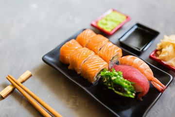 Top view on traditional japanese empty with sushi, ginger, soy sauce, wasabi bowl and chopsticks on concrete gray background. Online asian food delivery concept