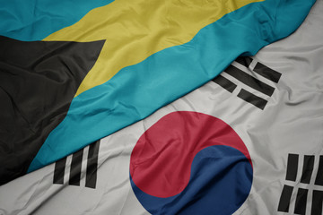 waving colorful flag of south korea and national flag of bahamas.