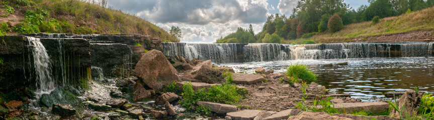 Panorama of waterfall on mountain river on summer day