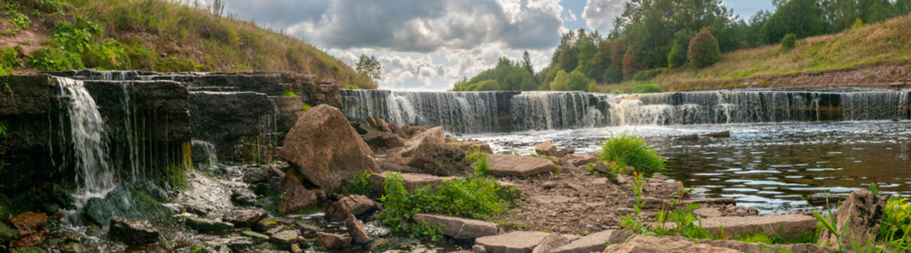 Panorama of waterfall on mountain river on summer day