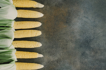 Raw Organic Corn On Dark Gray Background. Creative flat lay. Food concept
