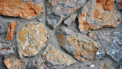Wall made of natural stone with a red tint.