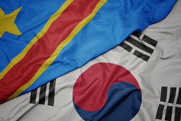 waving colorful flag of south korea and national flag of democratic republic of the congo.