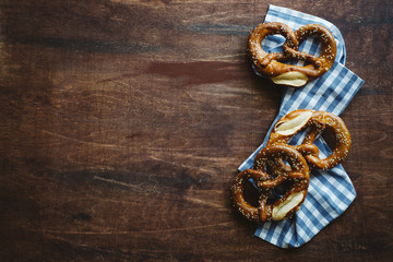 Sesame pretzels on dark brown wooden table. Traditional german appetizer. Oktoberfest background
