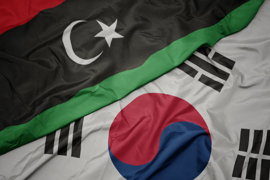 waving colorful flag of south korea and national flag of libya.