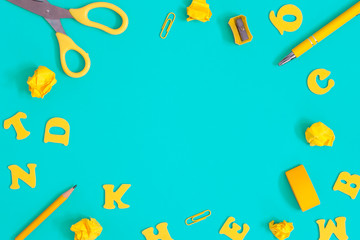Yellow school supplies on a blue desk.Back to school background