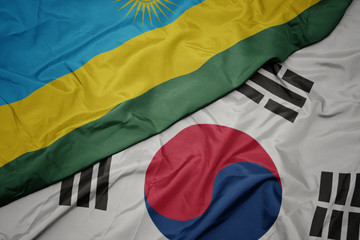 waving colorful flag of south korea and national flag of rwanda.