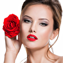 Fototapeta na wymiar Closeup face of beautiful woman with red rose bright makeup