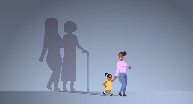 african american mother with daughter holding hands shadow of young and mature woman standing together imagination aspiration concept full length flat horizontal