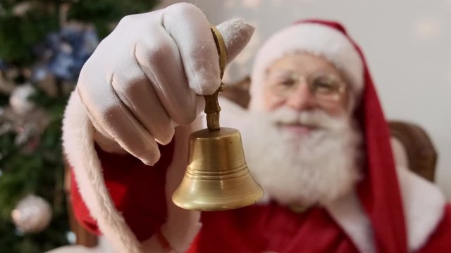Santa Claus ringing a small bell. Jingle Bells. Savings on purchases. Christmas is coming. Preparing for the Christmas night. Sales promotion. Cinematic 4K.