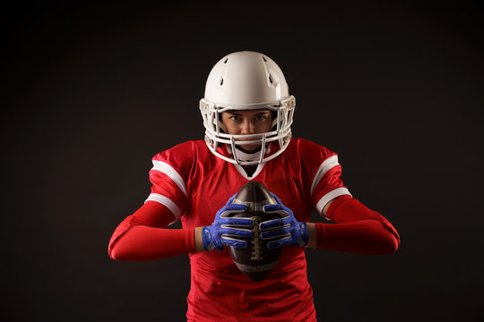 Photo Of American Female Football Player In Helmet With Rugby Ball In Hands