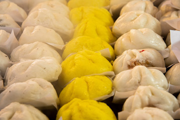 Various delicious steamed Chinese buns on steamer.