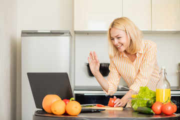 Woman using laptop in the kitchen