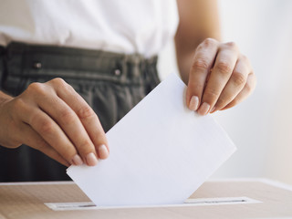 Woman placing ballot in box