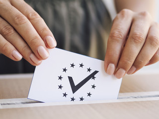 Woman placing ballot in box close-up