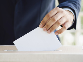 Man putting an empty ballot in election box