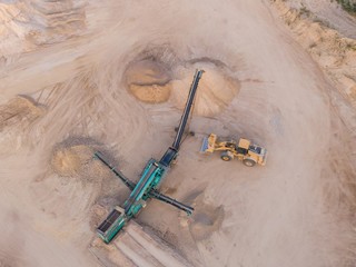 aerial view of a quarry with conveyor belt and wheel loader - stones and sands for construction - top view , open pit mine, extractive industry