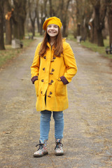 beautiful teenage girl in a yellow coat and beret in park autumn season
