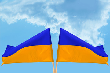 two state flags of Ukraine on a background of blue sky with clouds