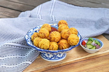 Deep Fried Wrapped Pork with Noodle Thai traditional snacks menu ( Thai name is Moo sarong) in Thai style bowl with cucumber salad and sweet chili sauce.
