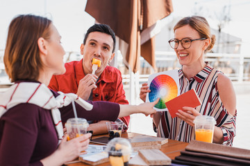 Designer showing to clients how to use color wheel