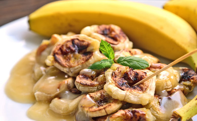 Grilled Bananas With Coconut- Caramel Sauce with fresh bananas on bamboo mat. Banana Thai Dessert menu.