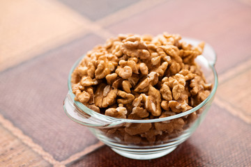 Studio photo of bowl with heap of peeled walnuts