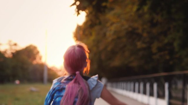 Cheerful child with a satchel behind his back runs towards the camera. Shallow depth of field video