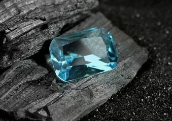 Fotobehang faceted blue jewelry gemstone aquamarine on black coal background © dimj