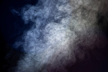 White and blue flow of steam on a black background