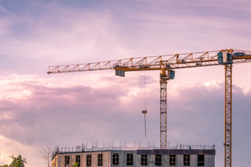 2 yellow cranes at construction site of premium apartment building