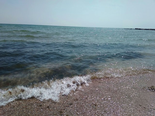 a clear sunny day on the shores of the azure sea. beautiful beach, blue sea and the sound of the surf