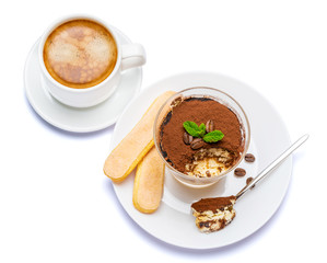 Classic tiramisu dessert in a glass cup, savoiardi cookies and coffee beans on white background with clipping path