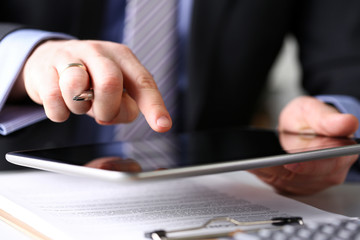 Male arm in suit and tie use silver pen and tablet pc