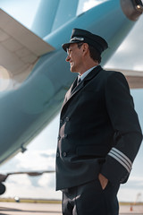 Adult pilot in uniform resting outdoors in airport