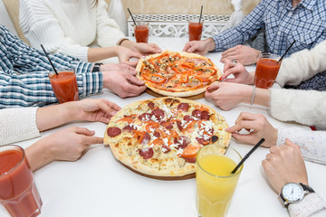 Friends eat pizza and drink juice in cafe. Close up