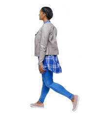 Side view of a young black girl walking in jeans and a checkered shirt.