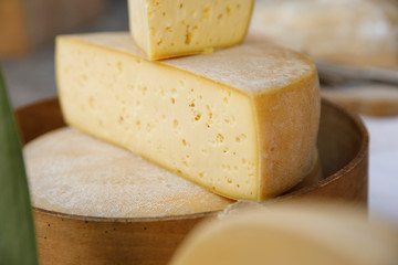 Parmesan cheese cut in half on wood plate.